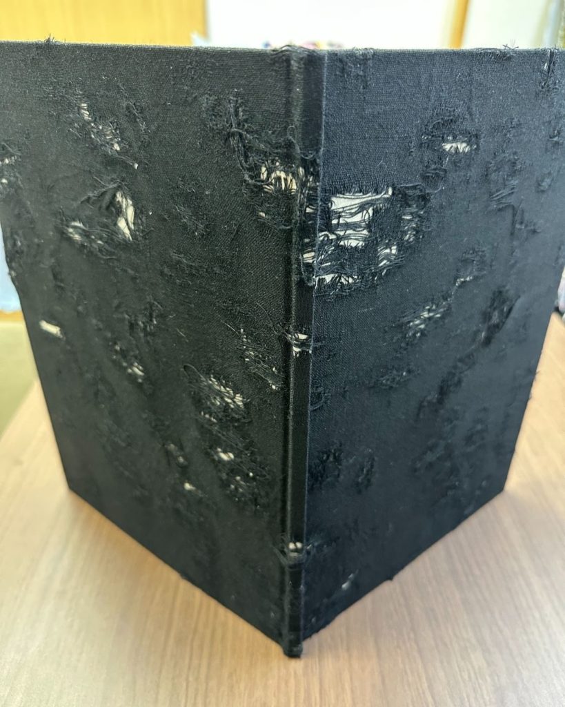 画像：ダメージ加工された布を表紙に使用。 繊細で扱いが難しい素材に挑戦しました。